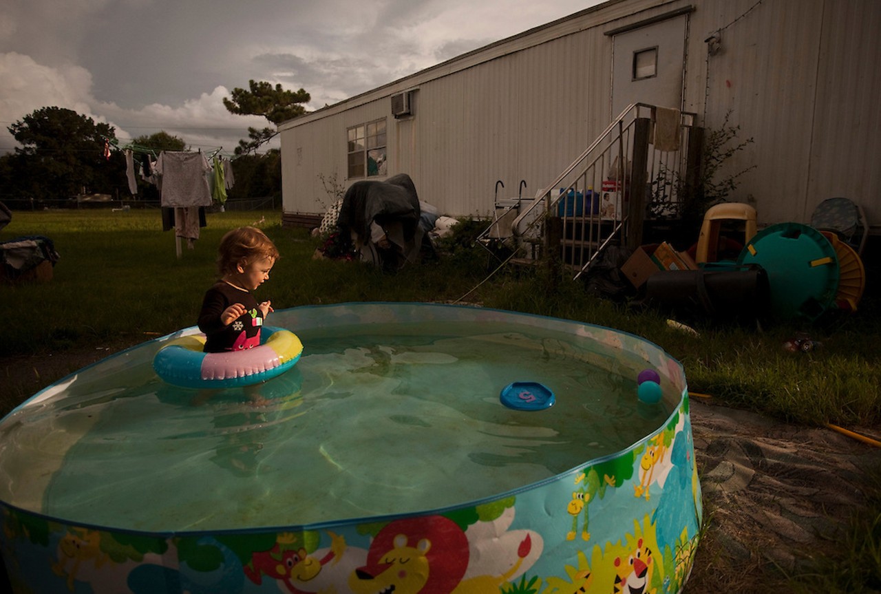 Dana's granddaughter splashes in the kiddy pool, recently "freshened" with rainwater. Dana's trailer is in the background. August 4, 2012.