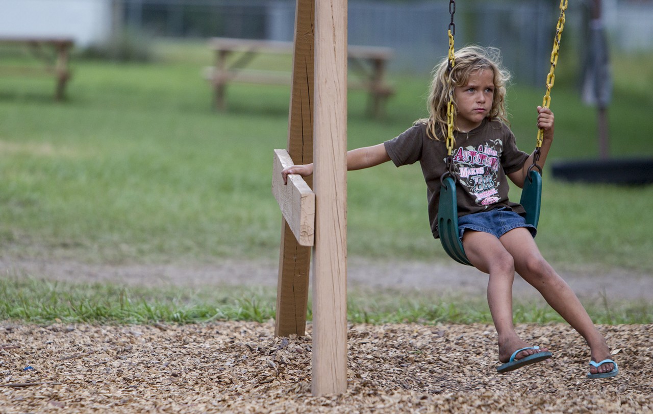 A young girl plays on the swings at one of the Thursday night cook outs at the Orange County Academy.