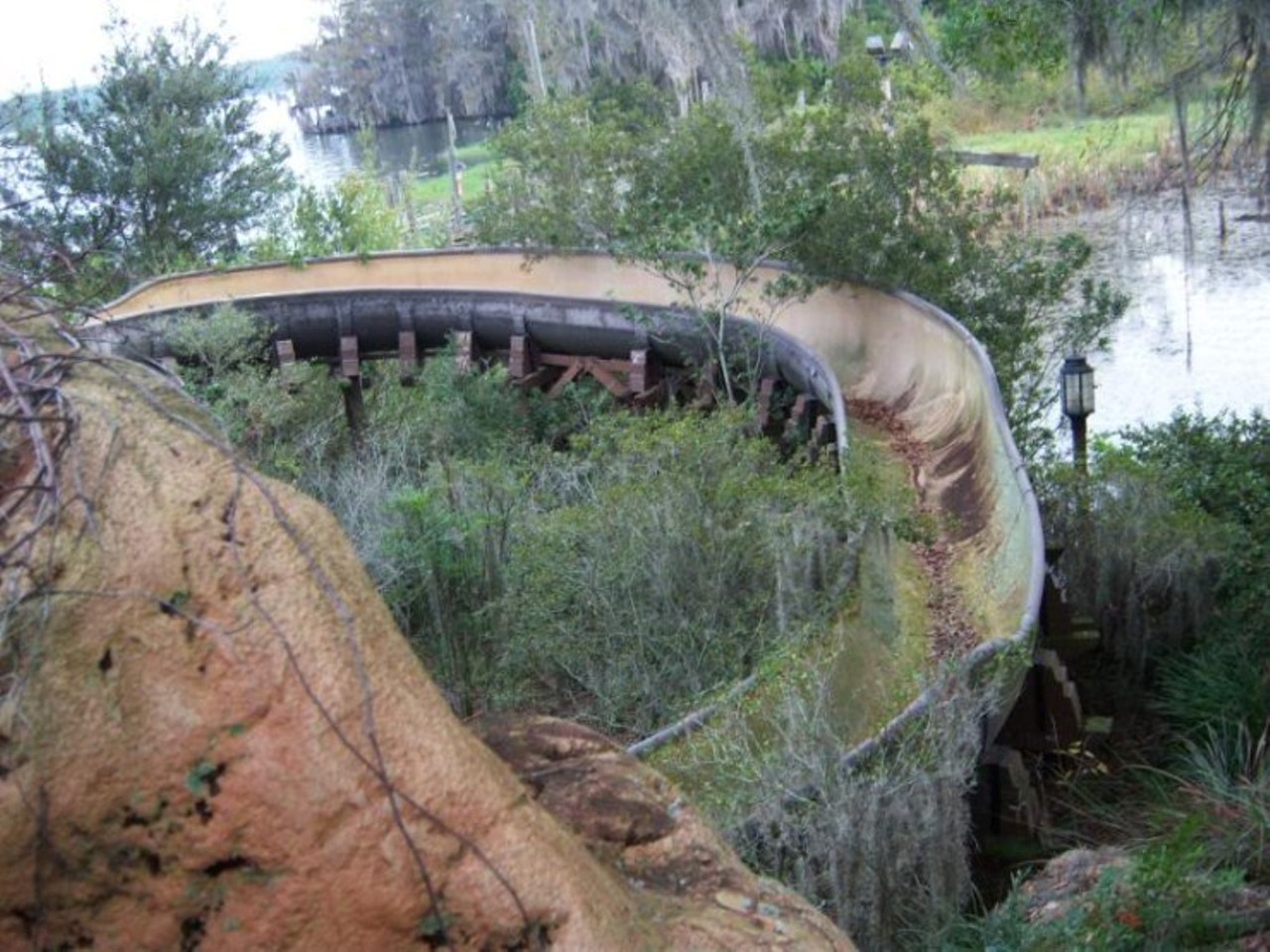 Even the waterslides are grown over. Via abandonedplaygrounds.com