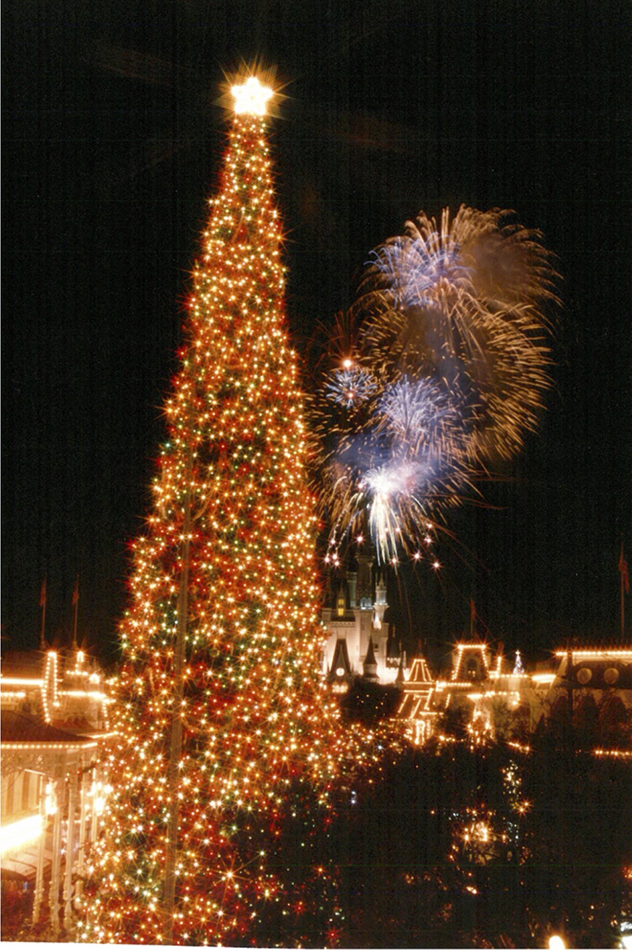 Fireworks explode behind a massive Christmas tree in the Magic Kingdom. 1991.