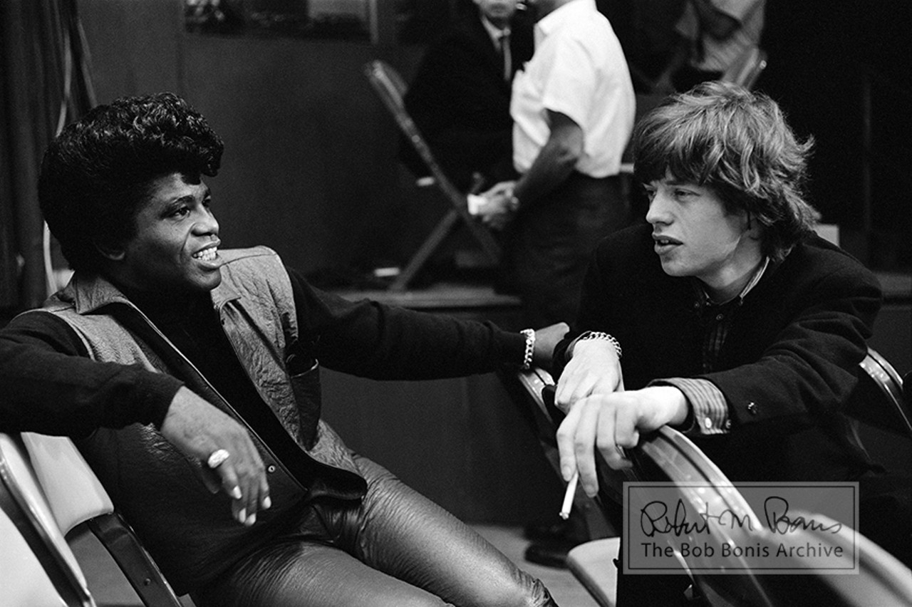 Mick Jagger and James Brown, Recording of T.A.M.I. Show, #1Just two dates into their second-ever U.S tour, the Rolling Stones performed in Santa Monica, California, for The T.A.M.I. Show, which stood for Teen Age Music International, although some publications called it Teenage Awards Music International. In this photograph taken October 28, 1964, on the rehearsal day of filming, Mick Jagger and James Brown &#150; meeting for the first time &#150; size each other up backstage. This truly rare image captures the interaction between the Stones and James Brown, and was immortalized in the James Brown biopic &#147;Get On Up&#148; that was produced by Mick Jagger last year.
