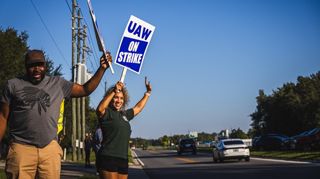 Kalilah Austin, a UAW member and employee of Stellantis/Chrysler, stands next to co-worker Alex on the picket line outside of a Stellantis parts depot in Orlando