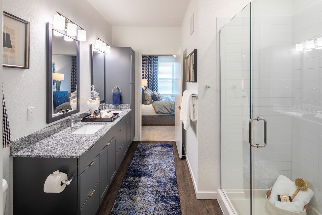 Spa-like bathrooms with double-vanity, built-in linen closet, subway tile, and glass-enclosed shower