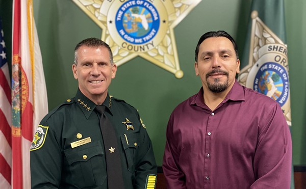 Orange County Sheriff John Mina stands with an AFSCME representative after both parties approved a new union contract covering some civilian employees (Oct. 7, 2022)