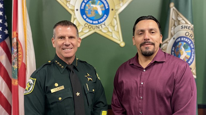 Orange County Sheriff John Mina stands with an AFSCME representative after both parties approved a new union contract covering some civilian employees (Oct. 7, 2022)