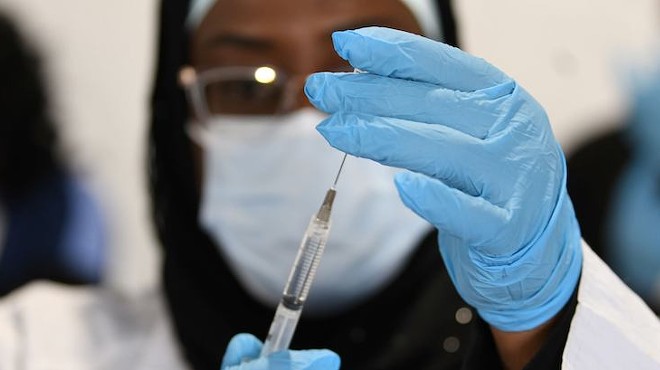 A FEMA worker prepares a COVID-19 vaccination syringe.