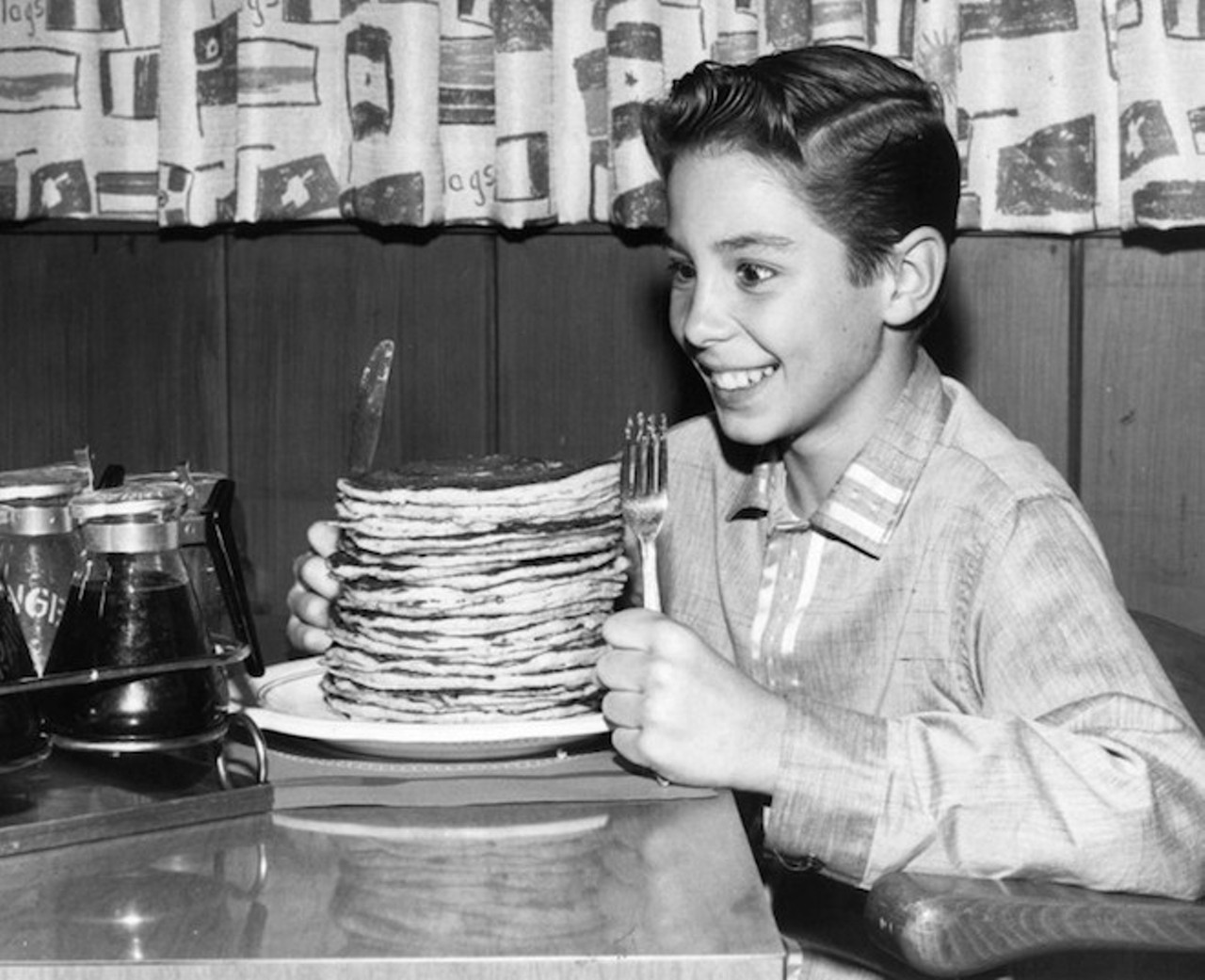circa 1960:  Child actor Johnny Crawford looks forward to eating a pile of pancakes in an International House of Pancakes, a chain of eateries in the USA started in 1958 by Californian brothers Al and Jerome Lapin.  (Photo by Keystone Features/Getty Images)