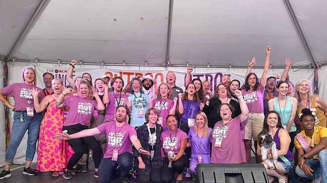 Fringe staff and board members, mostly in purple Fringe t shirts, standing on stage at Loch Haven Park.