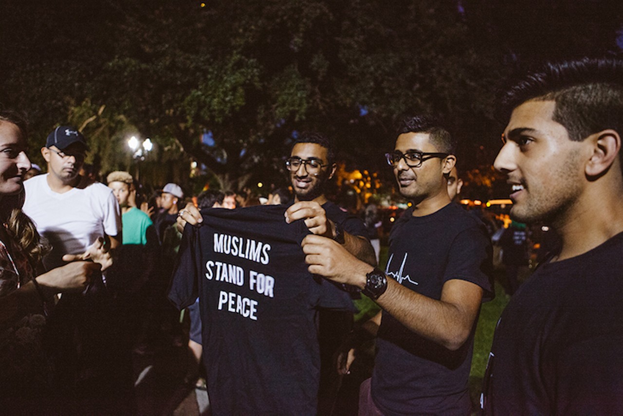 Members of the HIC Mosque in Sanford hand out free &#147;Muslims Stand for Peace&#148; T-shirts at the Lake Eola gathering Sunday night. Their mosque was vandalized on Monday, June 13, the day after the shootings.
Photo by  Hannah Glogower
