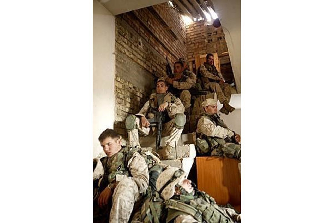 Marines from Fred's squad take a break in the midst of an afternoon clearing houses; Fred is pictured at the top of the stairs. The photo was taken by a Marine sergeant working for Stars and Stripes.