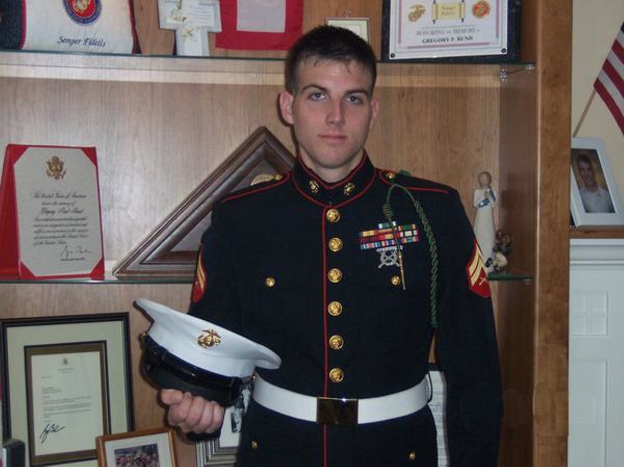 After exiting the Marines in 2006, Fred poses with his dress blues uniform in the home of Gregory Rund. A Littleton, Colo. native, Rund was killed in action during the Second Battle of Fallujah in Dec. 2004.