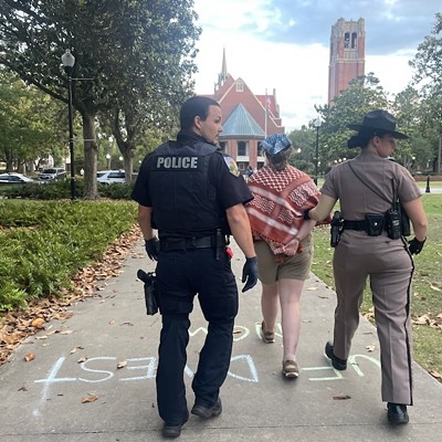 An unidentified University of Florida police officer and Florida Highway Patrol trooper walk a handcuffed protester away from the site on the university's campus where law enforcement arrested nine pro-Palestinian protesters late Monday, April 29, 2024. They were among the first such arrests on campuses in Florida.