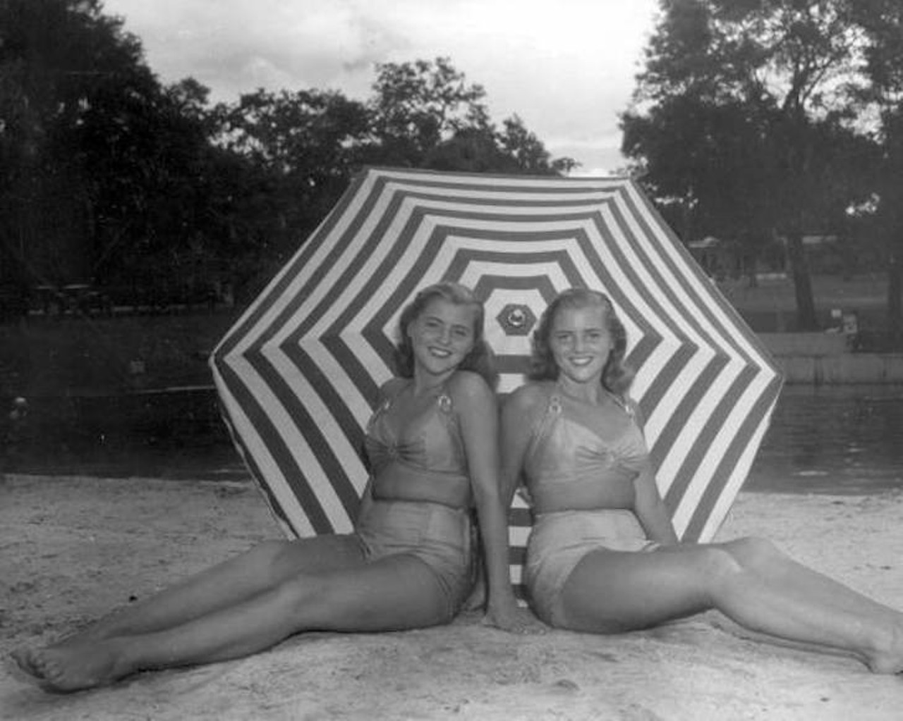 Unidentified women sit on the beach area of the springs - Sanlando Springs, 1946.