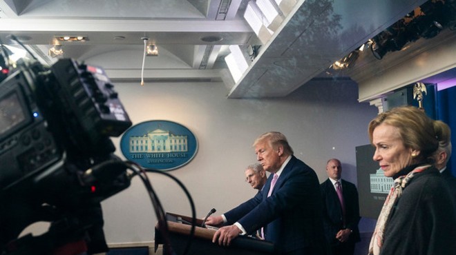 President Donald J. Trump is seen through the window taking questions from the press during a coronavirus update briefing Wednesday, April 1, 2020, in the James S. Brady Press Briefing Room of the White House.