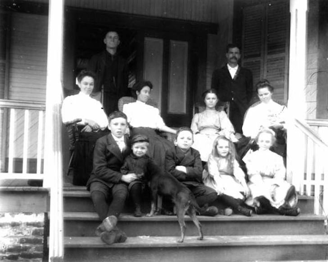 Group of Eastpoint people sitting on a porch, taken sometime between 1898 to 1912.