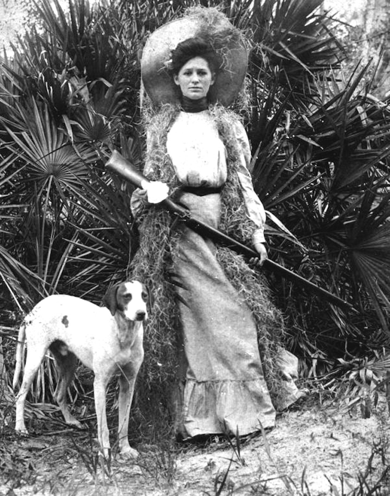 Woman with rifle and dog, taken in the 1910s.
