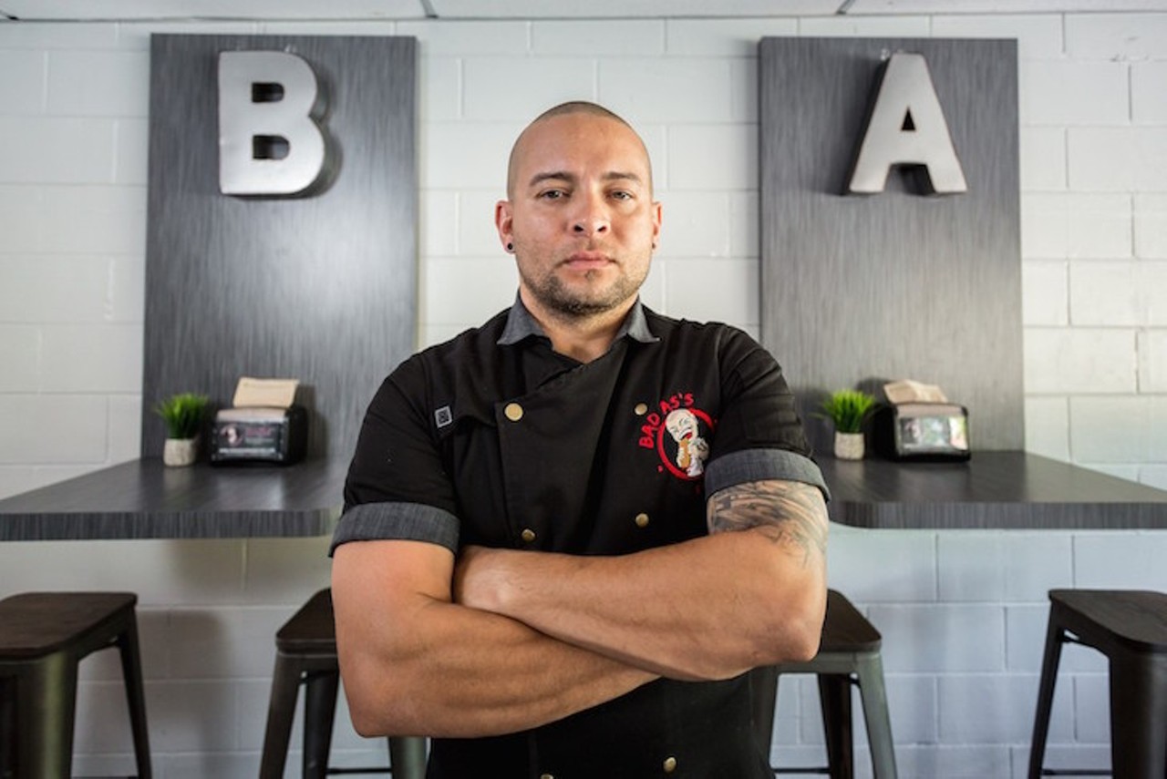 Photo by Rob Bartlett
John Collazo, Bad As's Sandwhiches 
Orlando's thriving food truck scene is a sure sign of its gastronomic health, and when food truck proprietors like John Collazo get into the brick-and-mortar game, all the more so. At Bad As's Sandwich, Collazo's Milk District eatery, the fruits of his labor come in the form of monstrous, sometimes decadent, always inventive sammies.
"We're located in an area where everyone is so creative that we have to continue to match that enthusiasm," says Collazo. "I love Orlando's growing diversity, and like to visit new restaurants and local favorites for inspiration."
And Bad As's sandwiches are unquestionably inspired. Case in point: the El Anormal #3, packed with adobo-roasted pork and peppery cantimpalo sausage, garnished with chipotle jack cheese, crispy onions, saffron aioli and a guava glaze. You'd be hard-pressed to find a more original sandwich in the city. For Collazo, diversity was one of the primary reasons he made the move from Allentown, Pennsylvania, to Orlando 10 years ago. In his estimation, multiplicity in food perspectives doesn't just unite and make this city better, it makes his restaurant better.
"We're surrounded by so many great restaurants that we want to diversify our flavors to make our sandwiches a bit different," he says. And clearly Collazo's supportive customer base appreciates it. "Just knowing they've enjoyed what I created makes it all worth it," he says, "because when they love you, they really show it." &#151;FK