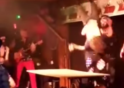 Watch this Orlando band member powerbomb a guy through a table during a show
