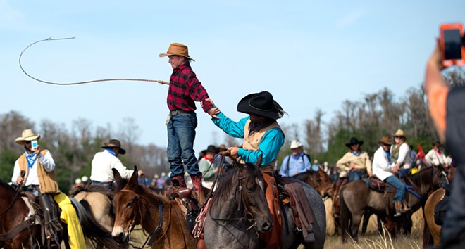 Justin Mickelsen, 13, stands atop his horse and cracks his whip. “Awesome,” said Mickelsen of Mobile, Alabama, about his six-day trip into the Florida wilderness.
