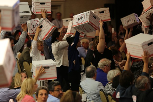Democratic delegates raise cardboard boxes meant to represent hundreds of thousands of signatures against the Trans-Pacific Partnership. - Photo by Joey Roulette