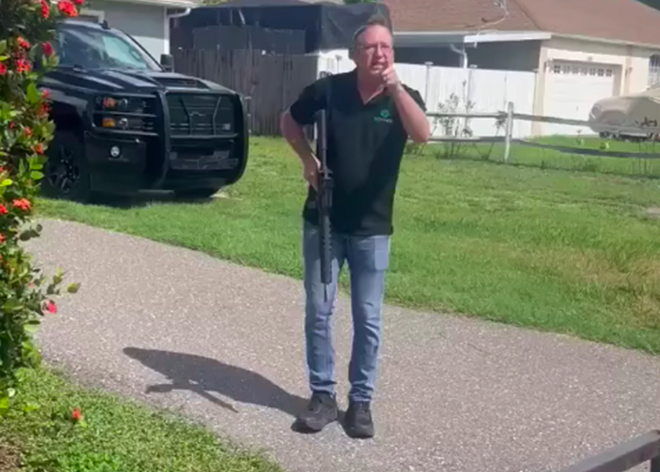 Screenshot from a video showing David H. Berry holding a gun while pointing and shouting at landscapers. - Screengrab via Jeremy Lee/Facebook
