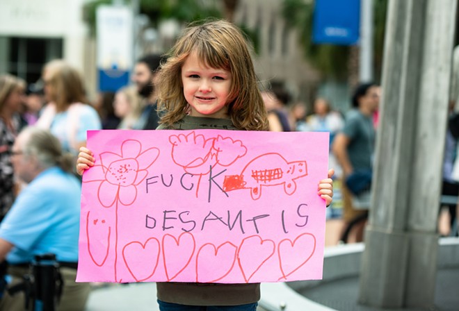 A child holds a sign reading "Fuck DeSantis" at an abortion rights rally in Orlando in January 2023. - Photo by Matt Keller Lehman