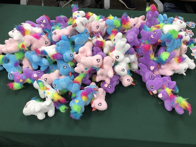 A table set up with craft supplies at a community event in support of trans Floridians also features unicorn plushes. - photo by McKenna Schueler