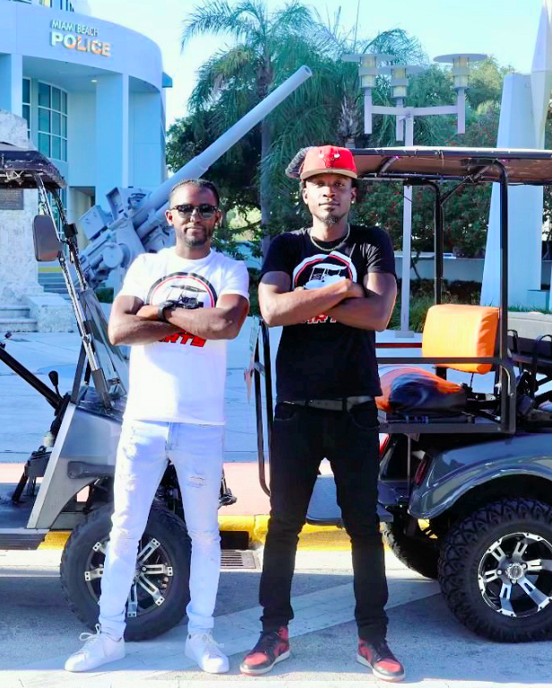 In this May 1, 2023, photo provided by Carven Exantus, 34, of Miami, left, Exantus and his business partner, Fred Laurice Johnson, 33, are seen standing in front of golf carts used by their business, Crew Cart Services LLC, near the Miami Beach Police Department headquarters. Exantus has been ticketed five times under a new law that allows police and sheriff’s deputies to ticket drivers for music that can be heard more than 25 feet away. Johnson has been ticketed four times. A new analysis of traffic data and court records shows Black drivers in Florida are nearly three times more likely to be ticketed under the law, which took effect last year. - Carven Exantus via Fresh Take Florida