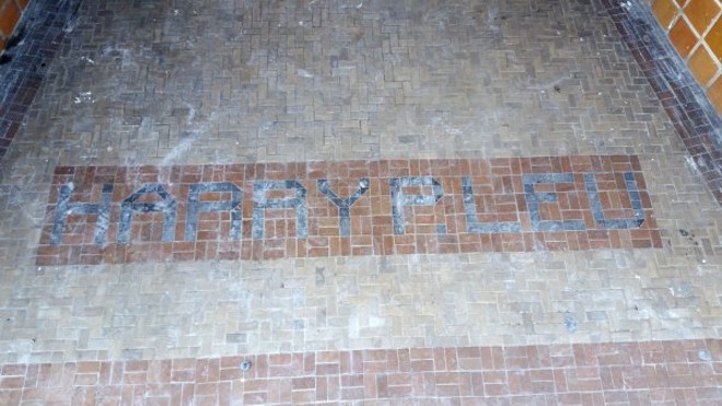 Tiled entrance on W. Livingston St. reading "Harry P. Leu"