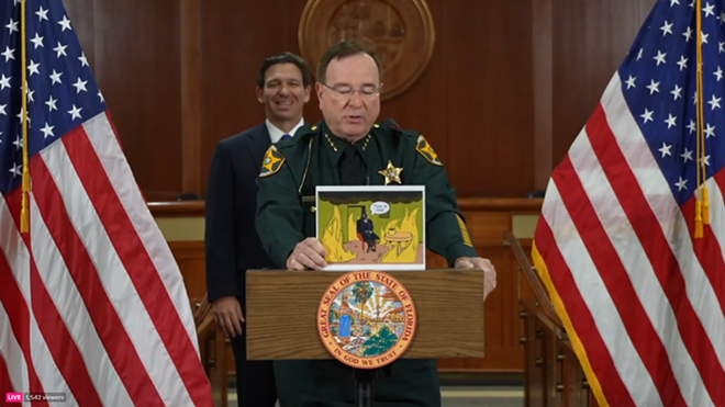 Polk County sheriff Grady Judd shows a meme featuring suspended state attorney Monique Worrell at a press conference announcing her suspension by Gov. DeSantis on Aug 9, 2023. - Florida Governor Ron DeSantis/Twitter