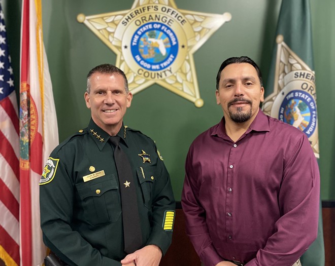 Orange County Sheriff John Mina stands with an AFSCME representative after both parties approved a new union contract covering some civilian employees (Oct. 7, 2022) - Orange County Sheriff's Office via Twitter/X
