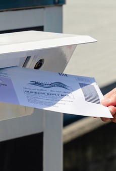 Putting a vote-by-mail ballot in the postbox.